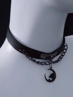 Elevate your gothic fashion with this stunning Gothic Black Moon Pendant PU Choker with Chains. Crafted from high-quality PU leather, this choker features a captivating black moon pendant. The intricate chain details add a touch of edginess. Adjustable for a comfortable fit. Gothic Metal Choker For Concerts, Gothic Choker For Concert, Gothic Chain Choker For Concerts, Black Choker For Alternative Fashion, Alternative Style Black Metal Choker, Black Metal Choker For Alternative Fashion, Black Metal Alternative Style Choker, Gothic Black Moon Phase Necklace, Black Gothic Moon Phase Necklace