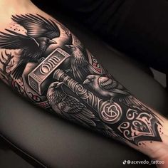 a black and white tattoo with two birds on it's arm, one is holding a