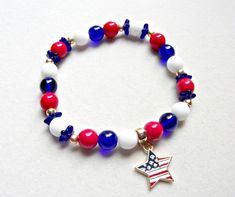 Red white and blue glass and gold seed bead stretch bracelet with American flag theme gold alloy star charm. Bracelet is 7 1/2 inches made of Czech round and flower bead cap beads with gold Czech seed beads. Gold tone bail and charm are lead and nickel free alloy. $1 of purchase will be donated to disabled veterans. I will match donation. Look for earrings in the patriotic section of the shop. Patriotic White Stretch Bracelet With Round Beads, Patriotic White Stretch Bracelet, Blue Stretch Bracelet For 4th Of July Gift, Patriotic Blue Beaded Stretch Bracelet, Blue Beaded Patriotic Stretch Bracelet, Patriotic Multicolor Stretch Bracelet For 4th Of July, 4th Of July Gift Round Beads Stretch Bracelet, Patriotic White Jewelry For 4th Of July, Patriotic Round Beads Stretch Bracelet For 4th Of July