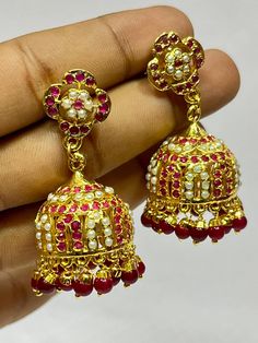 "Experience the royal heritage of Hyderabadi jewelry with this exquisite Jhumka set, handcrafted with love and precision. This stunning piece features: - Intricately designed brass Jhumkas adorned with Polki stones and Quartz stones - Delicate filigree work and textured details, reminiscent of traditional Hyderabadi craftsmanship - Dangling tassels that add movement and flair - Comfortable ear wires and a secure clasp for all-day wear Inspired by the rich cultural legacy of Hyderabad, this Jhumk 22k Gold Jhumkas For Ceremonial Navratri, Traditional Yellow Gold Jhumkas For Wedding, Ceremonial 22k Gold Jhumkas For Festive Occasions, Festive 22k Gold Jhumkas For Ceremonial Occasions, Festive Yellow Gold Jhumkas For Diwali, Festive Ceremonial 22k Gold Jhumkas, Yellow Gold Jhumkas For Navratri Gift, Navratri Gift Yellow Gold Jhumkas, 22k Gold Meenakari Jhumkas For Diwali