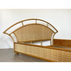 a bed made out of wood and wicker with a headboard on the side