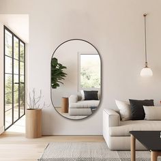 a living room with white furniture and a large round mirror