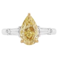 This charming 18K gold ring features a high-quality Pear drop Fancy Yellow Diamond at the centre, each side set with a tapered baguette White Diamonds. Unique and striking, this exceptional ring will add a touch of high glamour to any look. - Centre Diamond, GIA certified Pear shape Fancy Yellow Diamond 1.02 carat (color Fancy Yellow, clarity VVS2, certificate GIA 6345654950) - Tapered Baguette White Diamonds total 0.36 carat (color G, clarity VVS) - Made of 18K White and Yellow Gold - Ring Size US6 (can be sized upon request) Yellow diamond primarily originates from South Africa. Approximately 1 out 16,500 carats that are mined are yellow diamond, so it’s rare. HYT Jewelry is a privately owned company headquartered in Hong Kong, with branches in Tokyo, New York, and Bangkok. The company s 18k Gold Engagement Ring, Diamond Cocktail Ring, Fancy Yellow Diamond, Pear Cut Diamond, Diamond Cocktail Rings, 18k Gold Ring, Baguette Cut Diamond, Pear Diamond, Timeless Jewelry