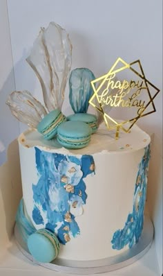 a white cake with blue frosting and cookies on top