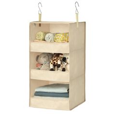 three shelves with stuffed animals and blankets on top of each shelf in the shape of a cube