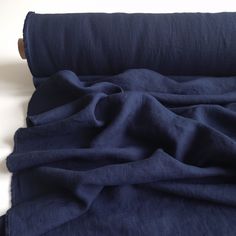 a blue blanket is folded on top of a white surface