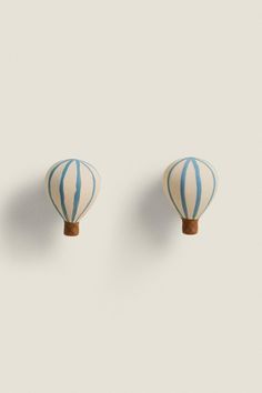 two blue and white striped hot air balloons on a light gray background, with one balloon in the middle