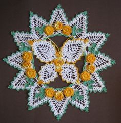 a crocheted doily with yellow flowers and leaves