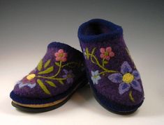 two purple slippers with flowers painted on them