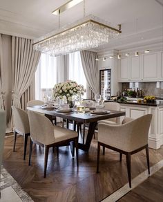 a dining room table with chairs and a chandelier hanging from it's ceiling