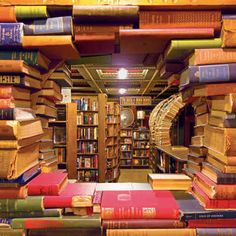 a room filled with lots of books next to a spiral stair case full of books