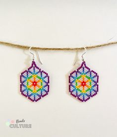 two small beaded earrings hanging from a string