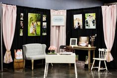 a black and white room with pink curtains, pictures on the wall and two chairs