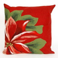 a red pillow with a poinsettia design on the front and green leaves on the back