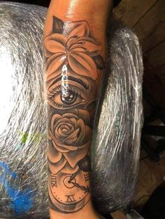 a woman's leg with an all seeing eye tattoo on it and roses around the clock