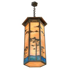 a hanging light fixture with a tree and sunset scene on the glass paneled ceiling