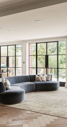 a living room with large windows and a sectional couch