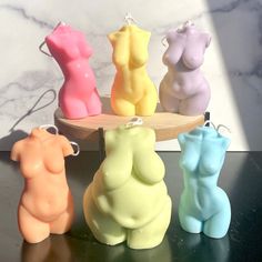 four different colored candles sitting on top of a table