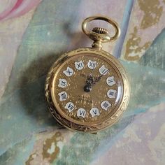 This is a vintage, Temlex Trading Co, Princeton, gold tone metal with floral designs, functional, pocket watch. The front reads Incabloc 17 Jewels. This was made in France. There is some very minor wear on this piece. All sales are final. This watch measures 43 mm in total length. If you have a wish list or are looking for something specific, please ask. I may have exactly what you are looking for. As always please convo me with any questions or concerns regarding this item or with any international shipping questions. Unfortunately I do not accept returns or grant refunds. All shipping fees include handling fees. If you would like to combine shipping costs for more than one item, I would be happy to do so if you convo me before purchase. Purchasing my item means you have read, understood Antique Gold Watches With Chronometer, Victorian Gold Watch With Chronometer, Victorian Style Gold Watch With Chronometer, Gold Victorian Style Pocket Watch For Formal Occasions, Victorian Gold Watch For Formal Occasions, Victorian Gold Formal Watch, Victorian Engraved Gold Watches, Vintage Engraved Gold Watches, Vintage Formal Watch With Stopwatch