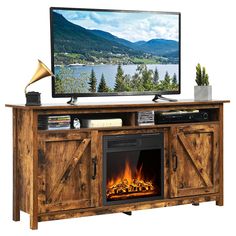 an entertainment center with a fire place and television on it's stand in front of a lake