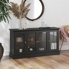 a black entertainment center with glass doors on the front and bottom, in a living room