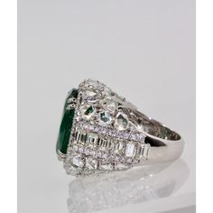 This is part of Chairish’s Fine Jewelry assortment.  Oval Emerald 12.25 Carat Diamond Surround 8.85 Carat Total Weight 21.10 Carat  This oval Emerald weights in at 12.25 carats and is a gorgeous Emerald Green with transparency. The Diamonds weigh in at 8.85 Carats and the mount is exceptional the Diamonds are VS1-VS2 and G-J in color. This is a bombe mount. The shoulders of the ring are embellished with baguette cut Diamonds in the center border with a perimeter of round cut Diamonds accents. Th Luxury Green Marquise Diamond Ring, Luxury Oval Emerald Cluster Ring, Luxury Marquise Emerald Ring, Luxury Pear-shaped Emerald Ring For Formal Occasions, Luxury Gia Certified Pear-shaped Wedding Ring, Luxury Diamond Cluster Ring With Gemstones, Exquisite Oval Emerald Ring In Platinum, Luxury Cluster Ring With Round Cut Gemstone, Luxury Oval Emerald Ring With Brilliant Cut