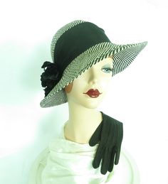 Woman's 70s hat made of black and white straw. Vintage 1970s hat crown is encircled with wide black grosgrain ribbon which anchors a black silk flower on the right. Brim increases from 2 in. at the back to 4 in. at the front. The 70s hat may be worn straight on the head or at a tilt. Unlined. -also included is a pair of black gloves -woman's hat label- " Street Smart by Betmar".  Union label -straw hat circumference- 22 1/4 in. -in excellent vintage condition.  -satisfaction guaranteed on all vintage hats -other women's vintage hats- http://TheVintageHatShop.etsy.com 70s Hats, Street Smart, Vintage Hats, Black Gloves, Silk Flower, Womens Gloves, Hat Making, Hats Vintage, Anchors