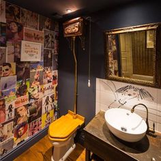 a bathroom with blue walls and pictures on the wall, including a yellow toilet seat