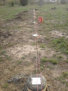 there is a pole in the middle of a field with several buckets on it