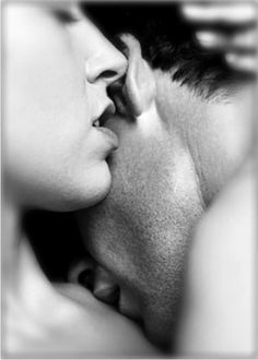 a man and woman kissing each other in black and white