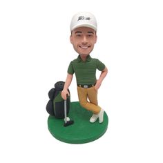 a bobble head with a golf player holding a club and bag on the green course