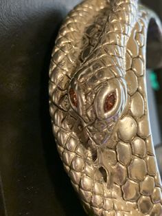 "Vintage shiny sterling silver textured snakeskin cuff with a coiled snake with amber rhinestone eyes. The inside length of the cuff is 5.75\" with a 1.25\" opening. The diameter is 6.75\" which would fit a medium wrist. The cuff is 1\" in width. The bracelet has an entire snake with a forked tongue. The pattern is that of snakeskin. The cuff weighs 46 grams." Elegant Engraved Silver Snake Ring, Elegant Silver Engraved Snake Ring, Luxury Silver Snake Ring, Elegant Silver Snake Ring, Silver Snake-shaped Bracelet For Parties, Silver Metal Snake Bracelet, Silver Metal Snake Bracelets, Silver Snake-shaped Ring For Formal Occasions, Silver Snake Ring For Formal Occasions