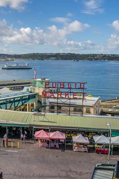 an aerial view of a pier with tents and people walking on the boardwalk next to it