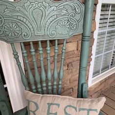 an old chair with a pillow that says rest on the front porch next to it