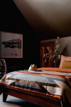 a bed sitting under a window next to a wooden dresser