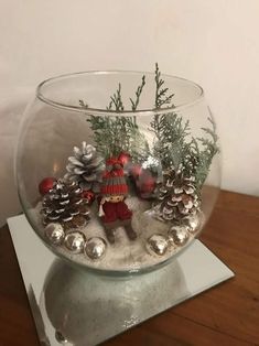 a glass bowl filled with snow and christmas decorations