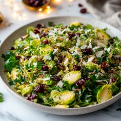 a salad with cranberries and brussel sprouts in a bowl