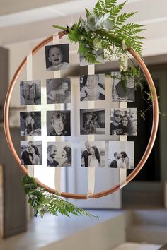 a wooden hoop with photos hanging from it's sides and greenery in the middle