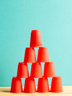 a group of orange cones sitting on top of a wooden table next to a blue wall