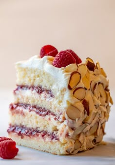 a piece of cake with raspberries and almonds on top