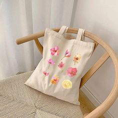 Floral Canvas Tote Bag, Pink and Yellow Grocery Bag,  Eco-Friendly Shopping Market Tote, Reusable Shoulder Bag, Wildflower Library Bag This floral canvas tote bag features a pink and yellow flower design, perfect for those who love nature-inspired accessories and want to add a pop of color to their everyday outfits. Ideal for shopping, running errands, or carrying essentials to the beach or park. Great for spring and summer seasons, picnics, and outdoor activities. Product description: ★ Design printed on both sides ★ Size: 15'' x 16'' ★ 100% Cotton canvas for durability ★ Flat corners for a sleek design ★ Reinforced stitching on carrying handles ★ Heavy fabric for lasting quality Care instructions ★ Do not iron directly over the printed area - print may stick to the iron. ★ Spot clean ★ D Yellow Flower Design, Nature Inspired Accessories, Shopping Market, Library Bag, Floral Canvas, Market Tote, Pink And Yellow, Yellow Flower, Canvas Tote Bag