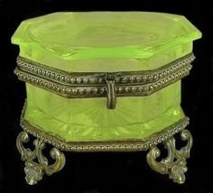 an antique green glass jewelry box with silver trimmings