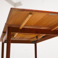 a close up of a wooden structure with metal brackets on it's sides and a white wall in the background