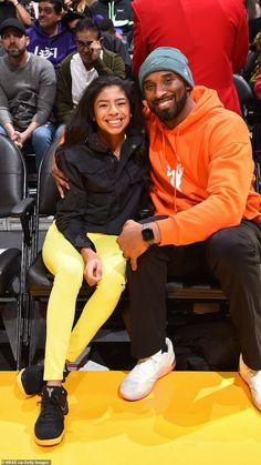 a man and woman sitting next to each other at a basketball game