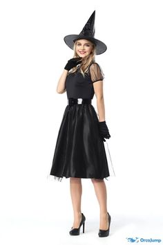 a woman in a black dress and witch hat is posing with her hand on her hip