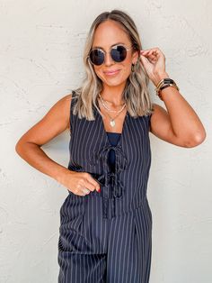 Effortlessly elevate your style with our Take A Moment Pin Stripe Front Tie Vest. Made from a comfortable and durable linen blend, this black vest features white pinstripes and a v-neckline for a sleek look. Complete with a front tie closure, pair it with our matching Wait List Pin Stripe Pants for a sophisticated and coordinated outfit. V-neckline Sleeveless Front tie closures Linen blend fabrication Fit: Relaxed; No stretch Bust: Small-34in Medium-36in Large-38in Length: Small-19in Medium-20in Pin Stripe Pants, Tie Vest, Athleisure Summer, Maxi Outfits, Stripe Pants, Pin Stripe, Black Vest, Jumpsuit Shorts Rompers, Printed Jumpsuit