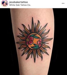 a sun tattoo on the leg with flowers and leaves around it's center piece