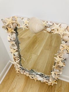 there is a mirror made out of seashells on the floor