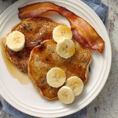 two pancakes with bacon and banana slices on a plate