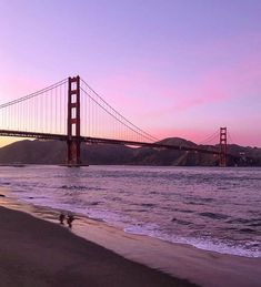 the golden gate bridge in san francisco, california at sunset with waves crashing on the beach